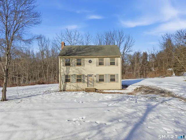 a view of a house with a yard covered in snow