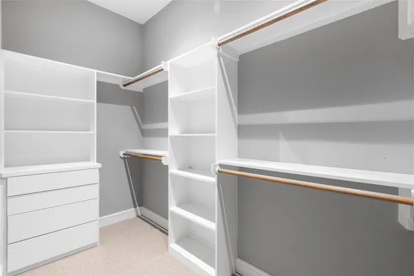 a spacious bedroom with a bed and a mirror