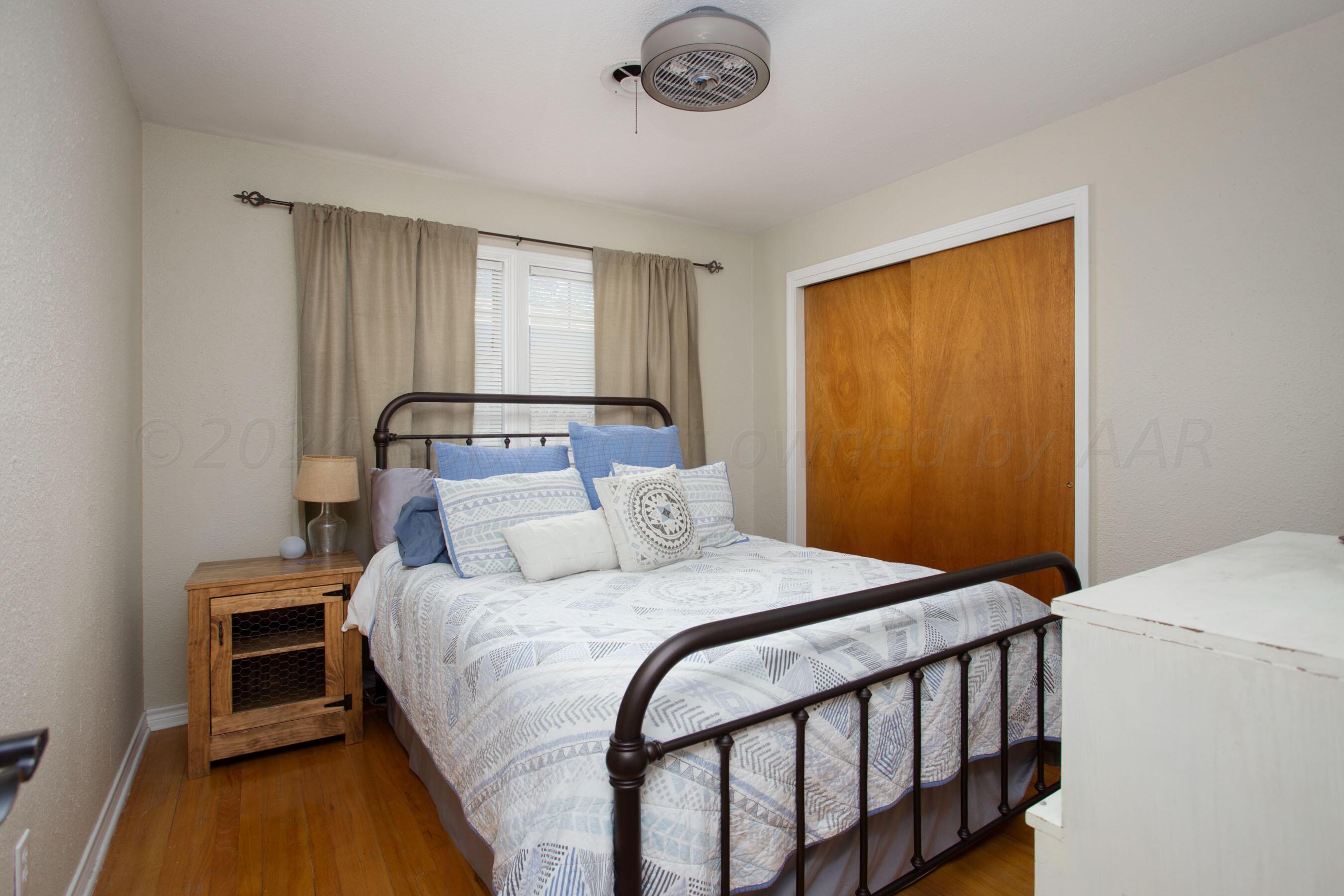 4406 South Bonham Street Amarillo, TX 79110 - Photo 13 of 26 a bedroom with a bed and a chandelier