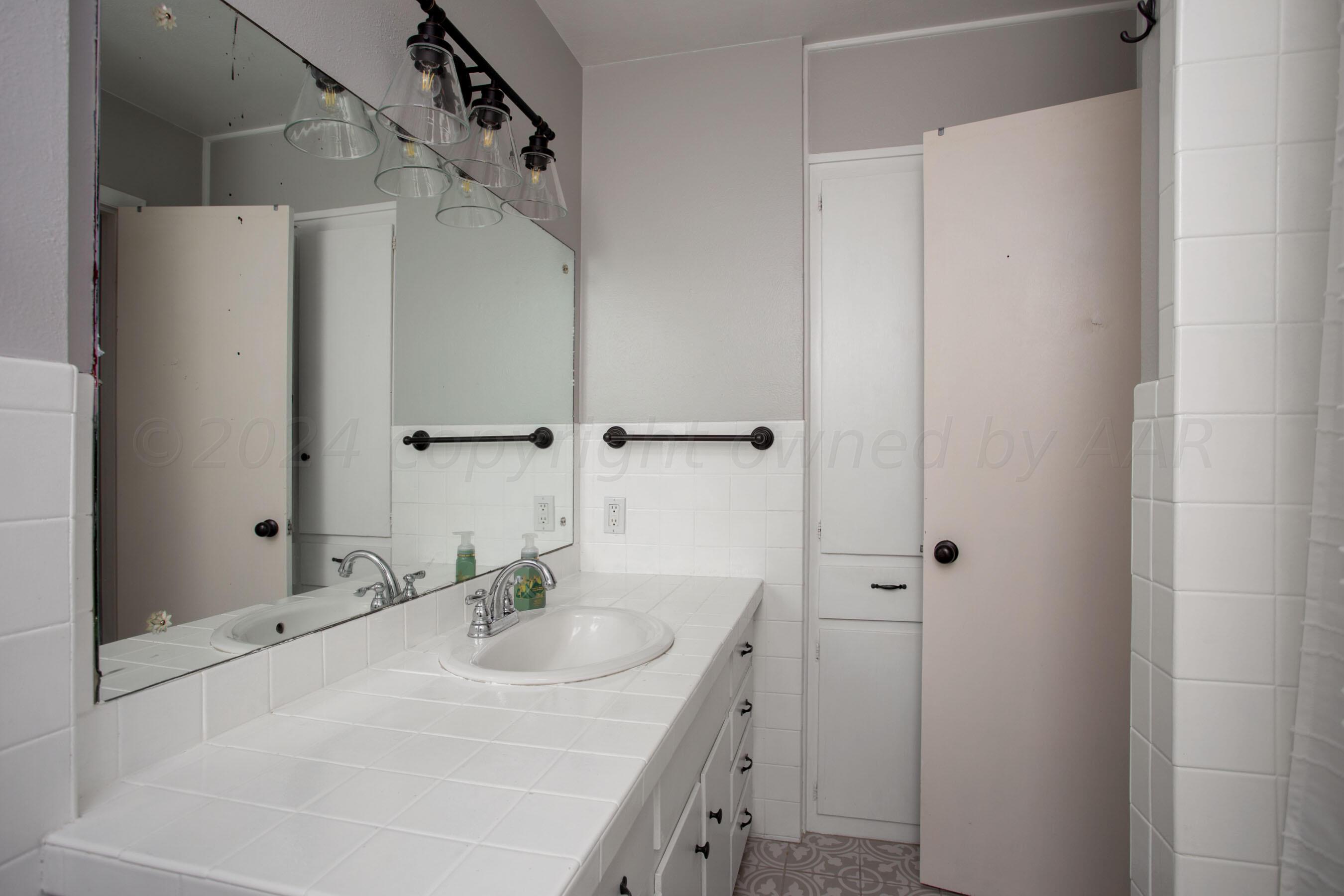 4406 South Bonham Street Amarillo, TX 79110 - Photo 15 of 26 a bathroom with a sink and a mirror