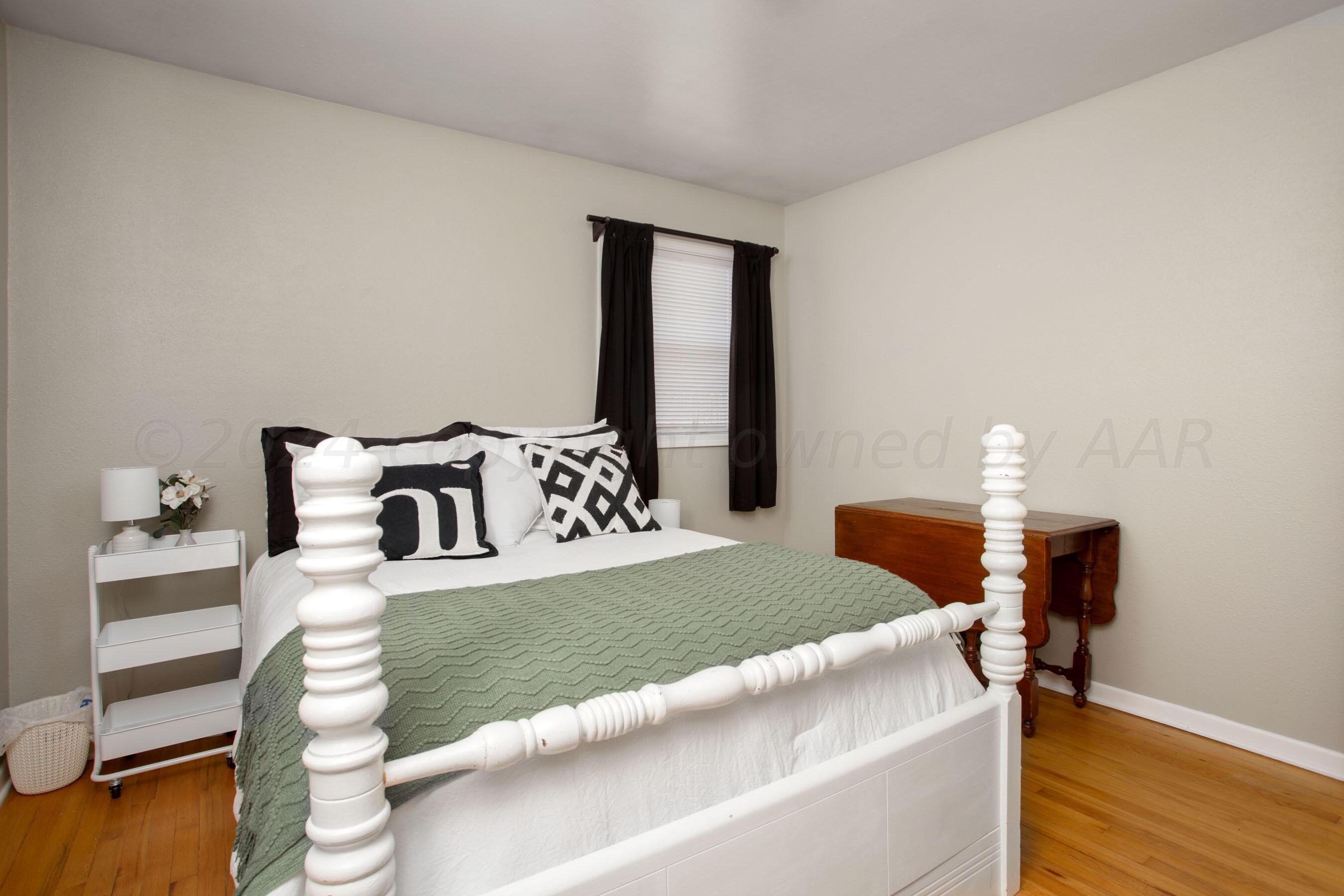 4406 South Bonham Street Amarillo, TX 79110 - Photo 17 of 26 a bedroom with a bed and a lamp on table