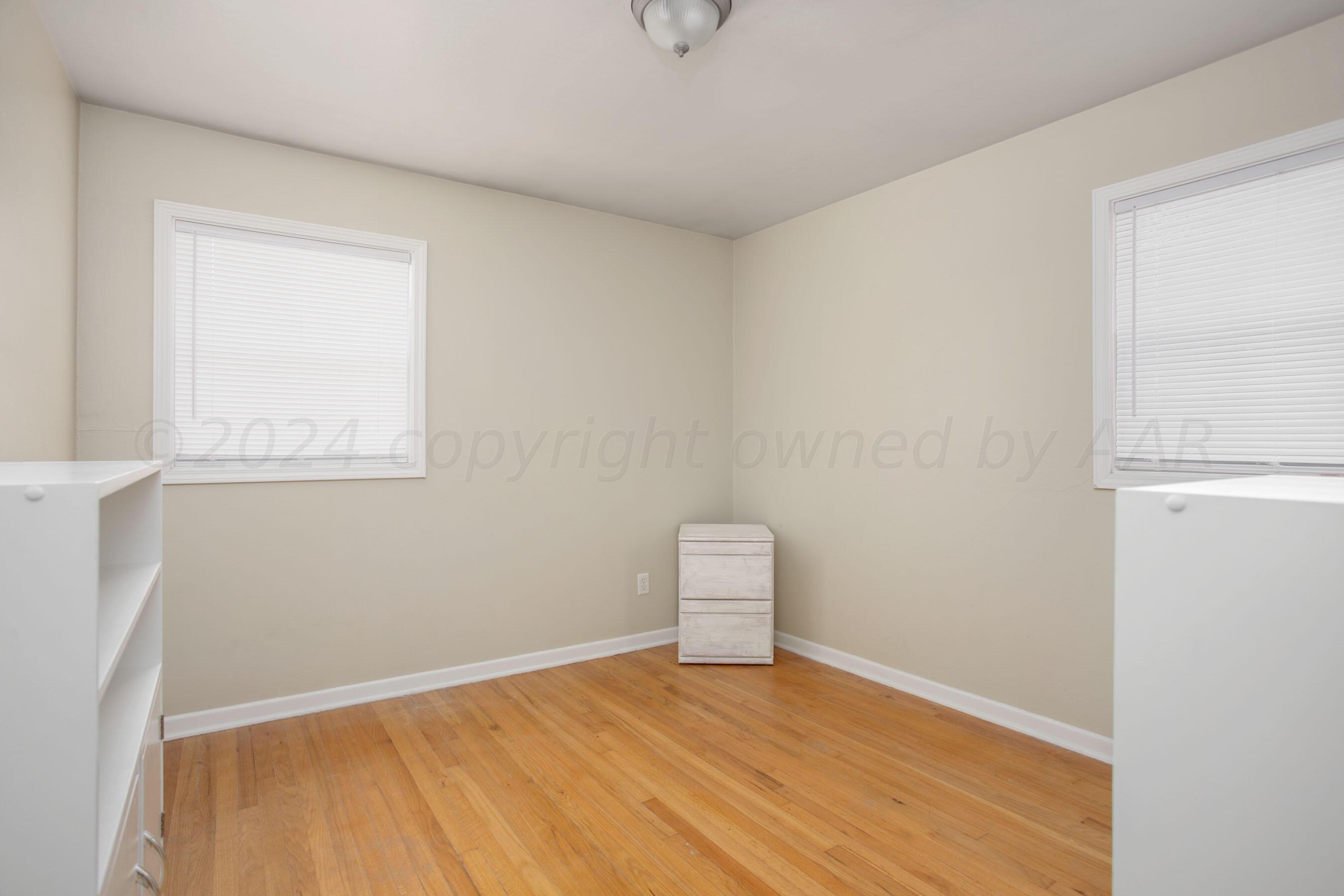 4406 South Bonham Street Amarillo, TX 79110 - Photo 18 of 26 a view of an empty room with wooden floor and a window