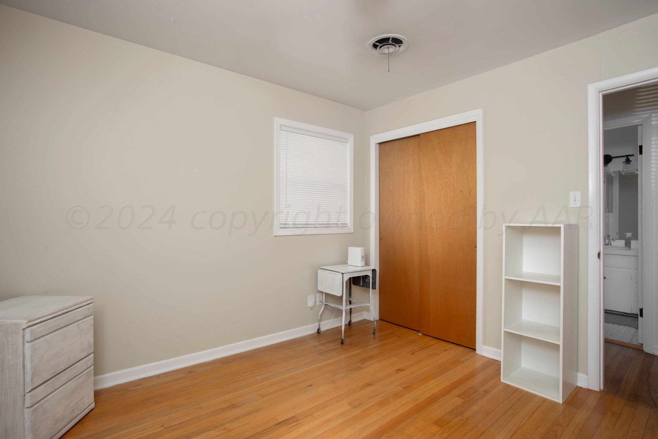 4406 South Bonham Street Amarillo, TX 79110 - Photo 19 of 26 a view of an empty room with wooden floor and a bathroom