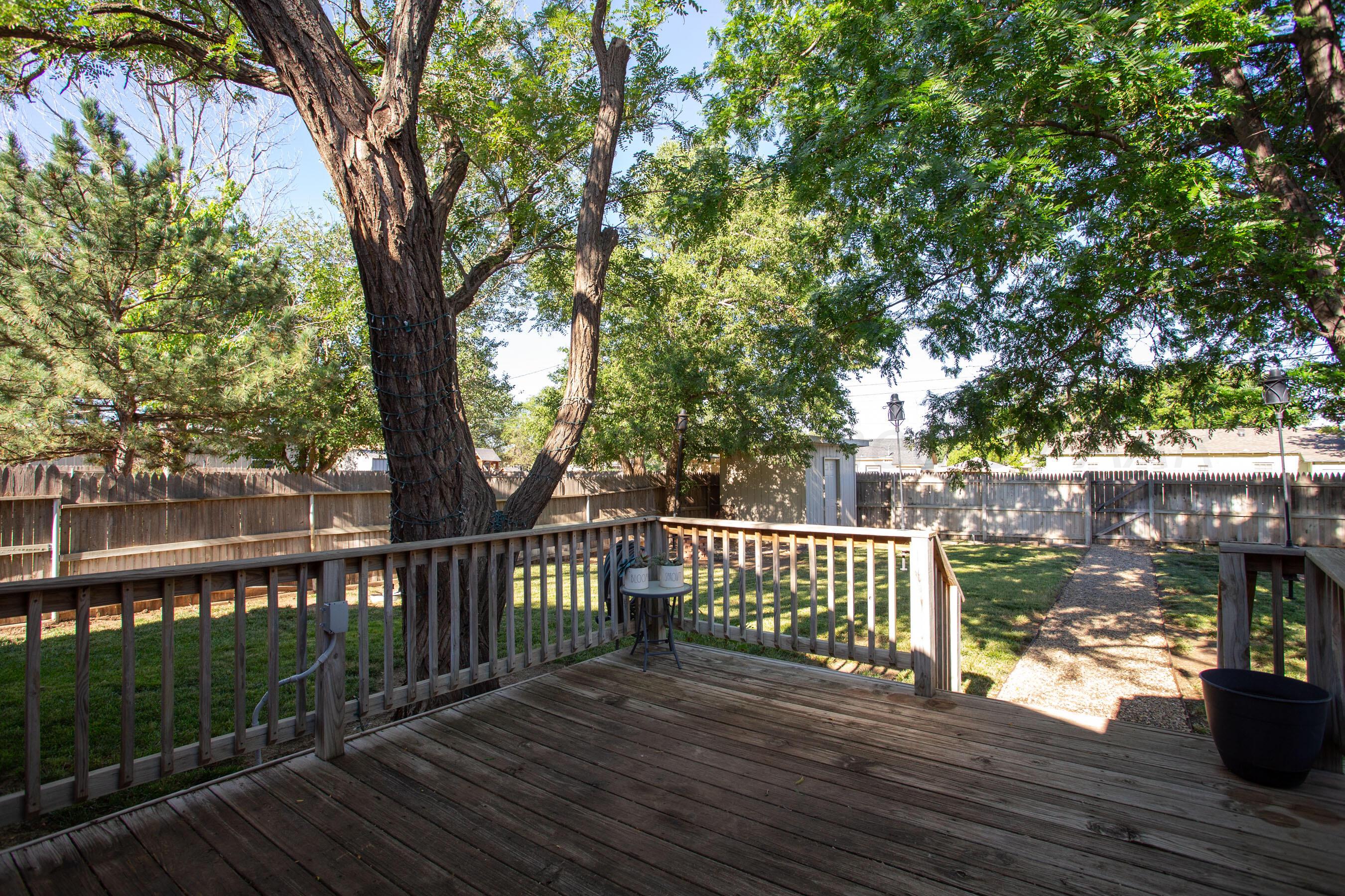4406 South Bonham Street Amarillo, TX 79110 - Photo 20 of 26 a view of a deck with a table and chairs next to a yard with wooden fence