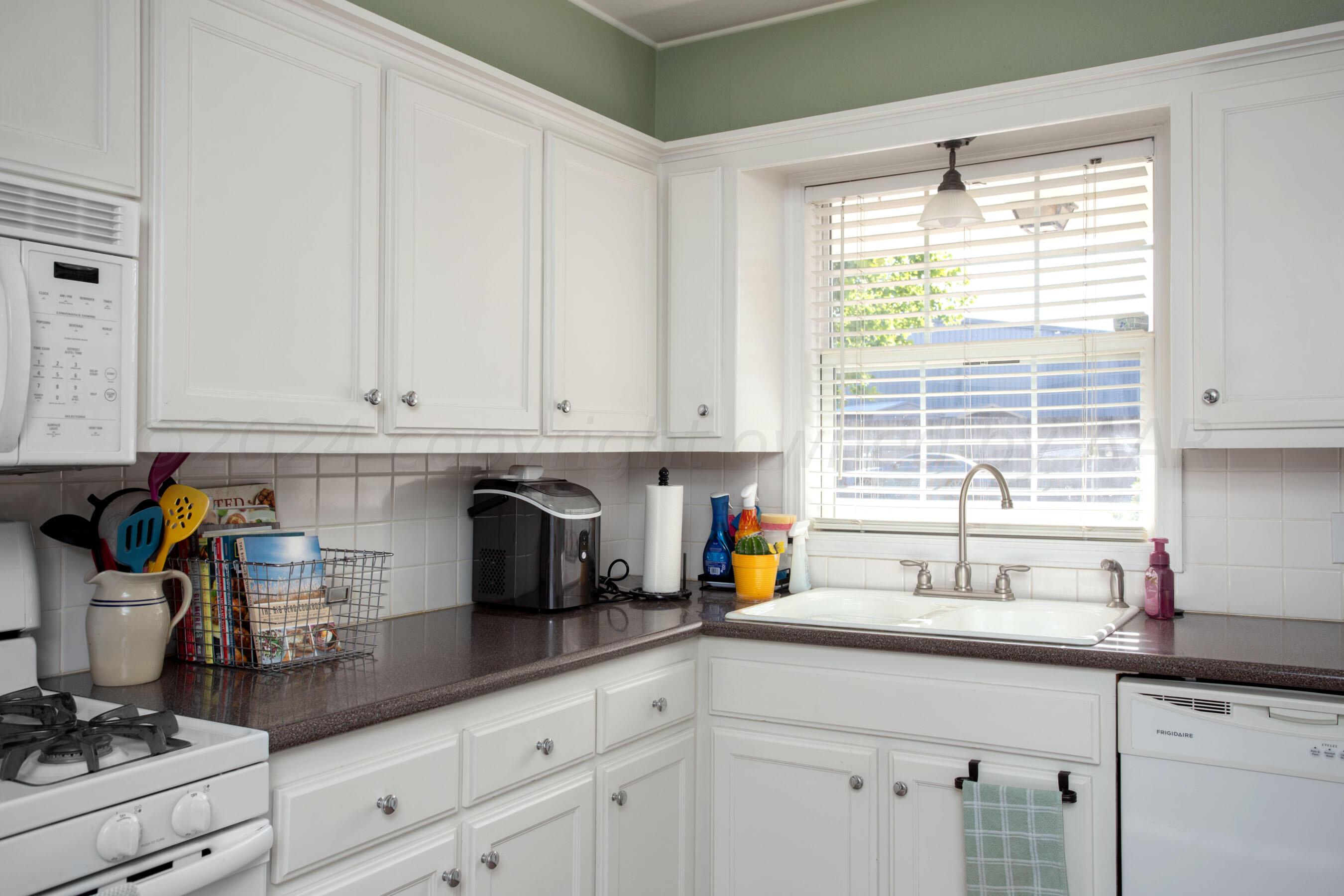 4406 South Bonham Street Amarillo, TX 79110 - Photo 9 of 26 a kitchen with stainless steel appliances a sink a window and cabinets