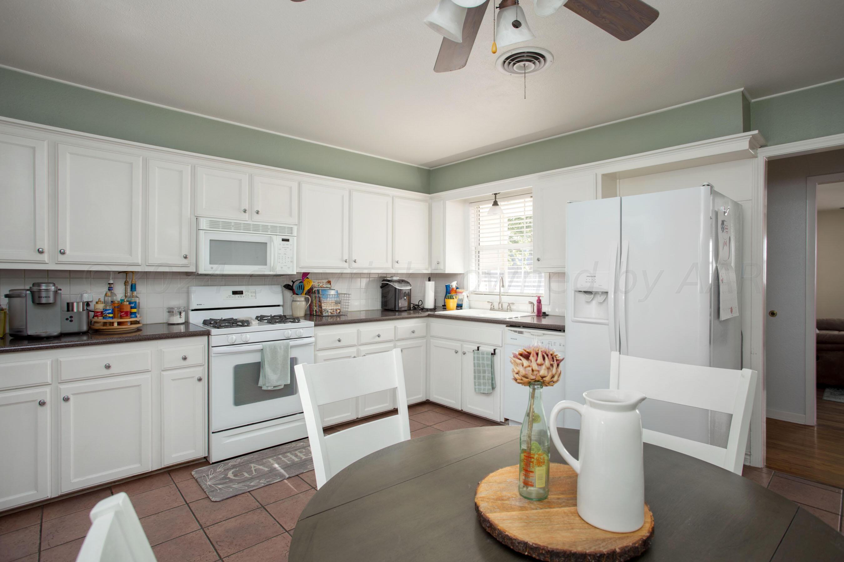 4406 South Bonham Street Amarillo, TX 79110 - Photo 10 of 26 a kitchen with white cabinets and white appliances