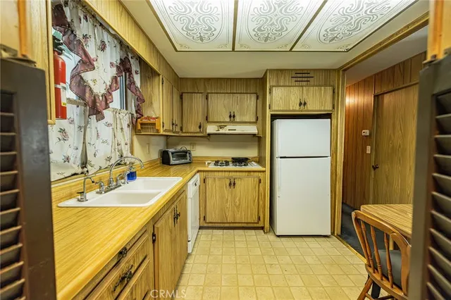 a view of a kitchen with a sink and refrigerator