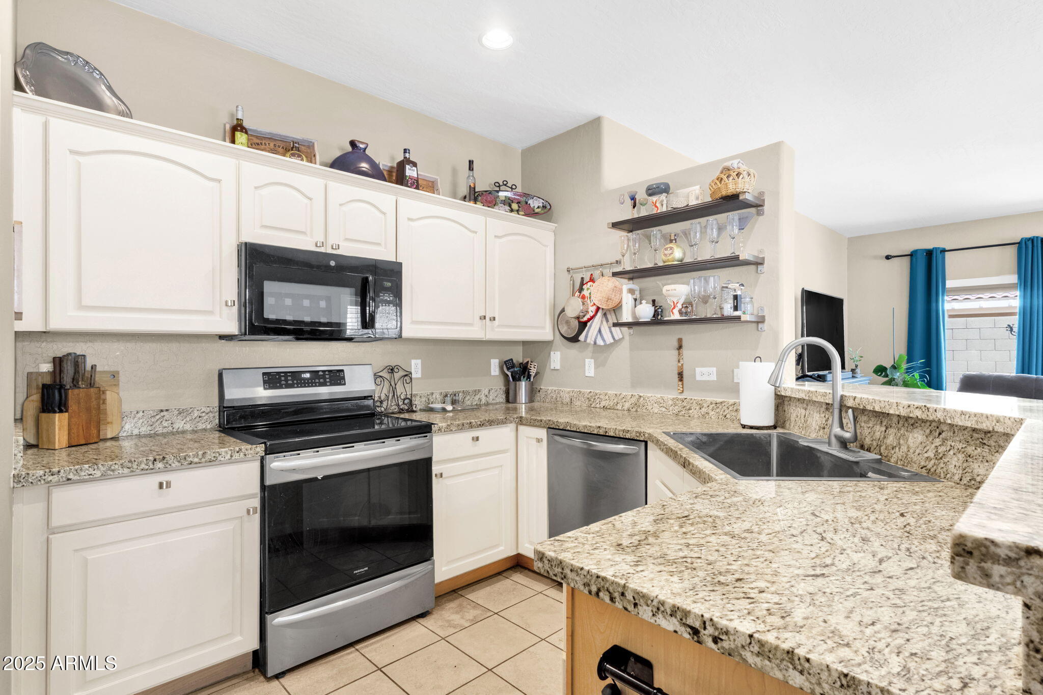 6456 South Nash Way Chandler, AZ 85249 - Photo 3 of 57 a kitchen with stainless steel appliances granite countertop a sink stove oven and white cabinets