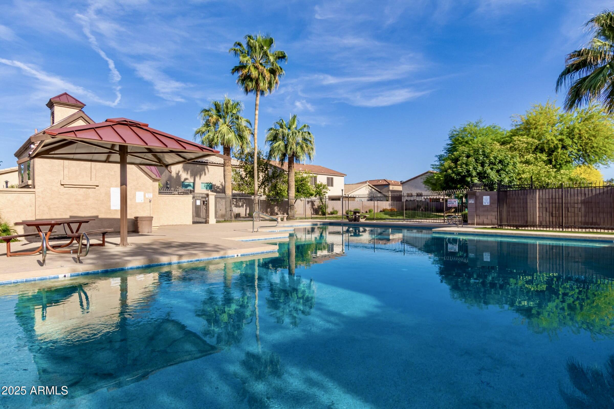 6456 South Nash Way Chandler, AZ 85249 - Photo 44 of 57 a view of a swimming pool with a table and chairs under an umbrella