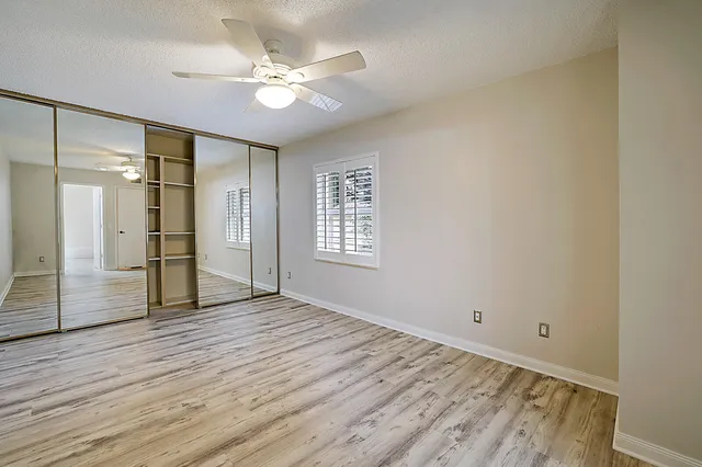a view of empty room with wooden floor