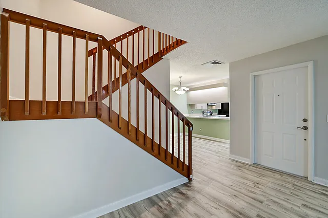 a view of staircase with railing and white walls