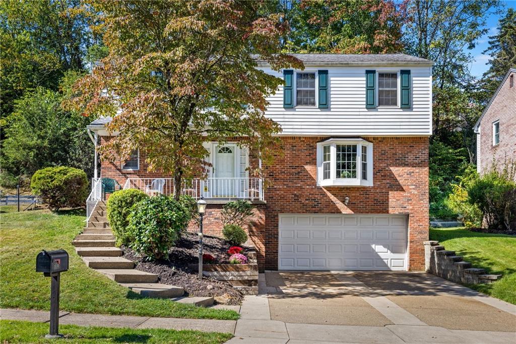 a front view of a house with a yard and tree s