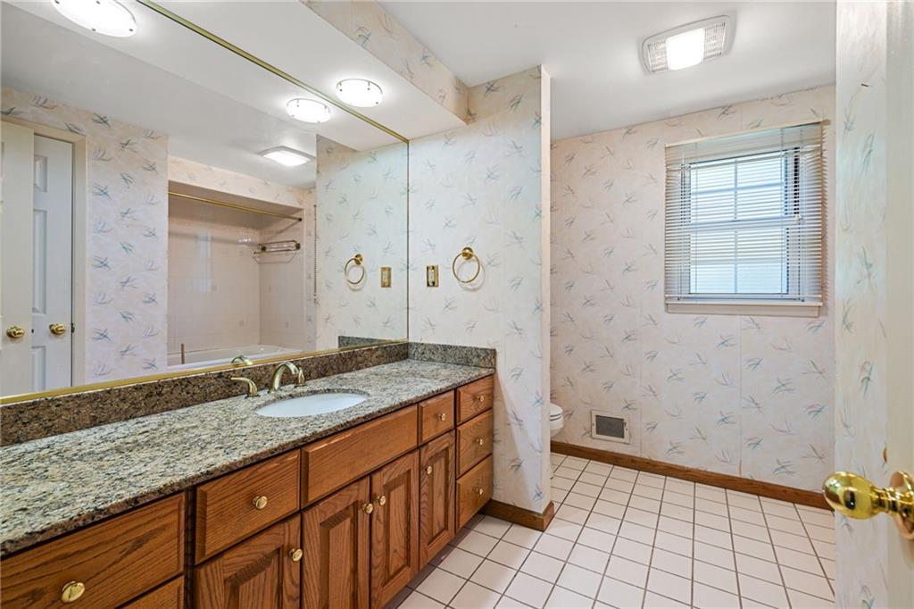 110 Atterbury Road Monroeville, PA 15146 - Photo 26 of 36 a bathroom with a granite countertop sink and a mirror a bathtub