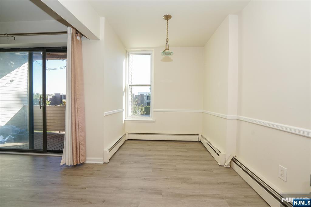 1 River, Unit 3G Nutley, NJ 07110 - Photo 12 of 25 an empty room with wooden floor and windows