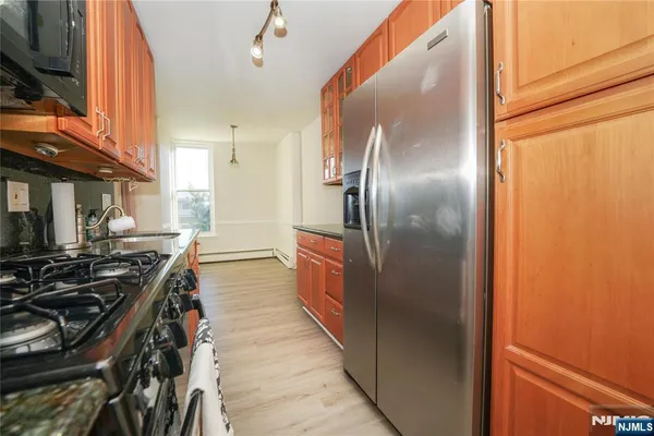 a kitchen with stainless steel appliances granite countertop a refrigerator and a stove