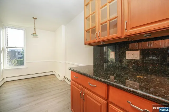 a kitchen with granite countertop wooden cabinets and a counter top space