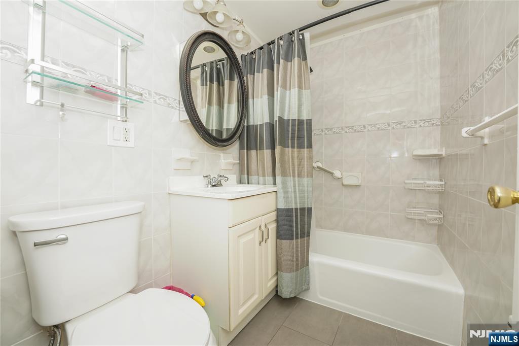 1 River, Unit 3G Nutley, NJ 07110 - Photo 5 of 25 a bathroom with a sink a mirror a toilet and a bathtub