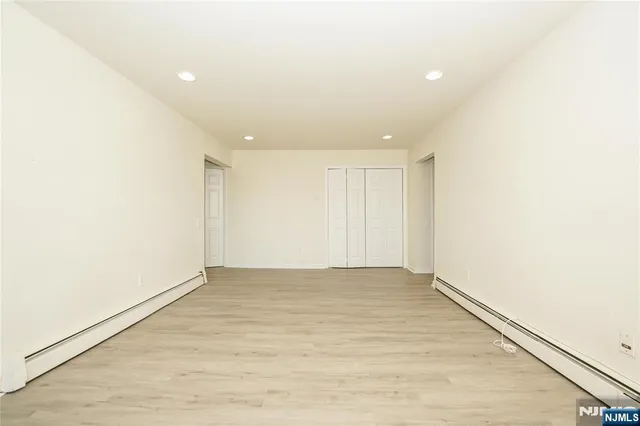 an empty room with wooden floor and white walls