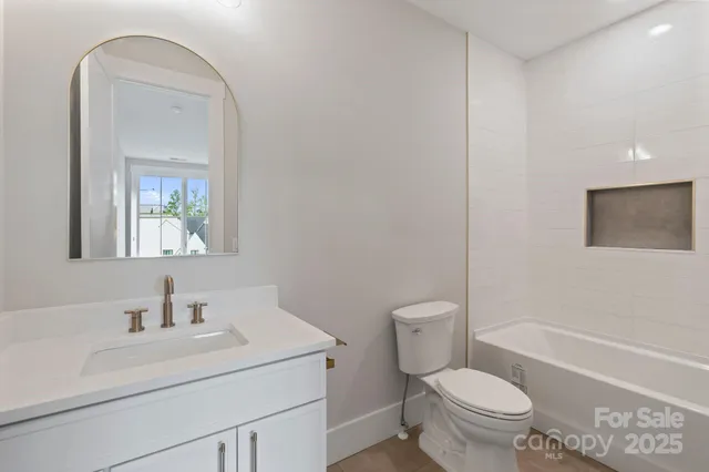 a bathroom with a sink toilet vanity and tub