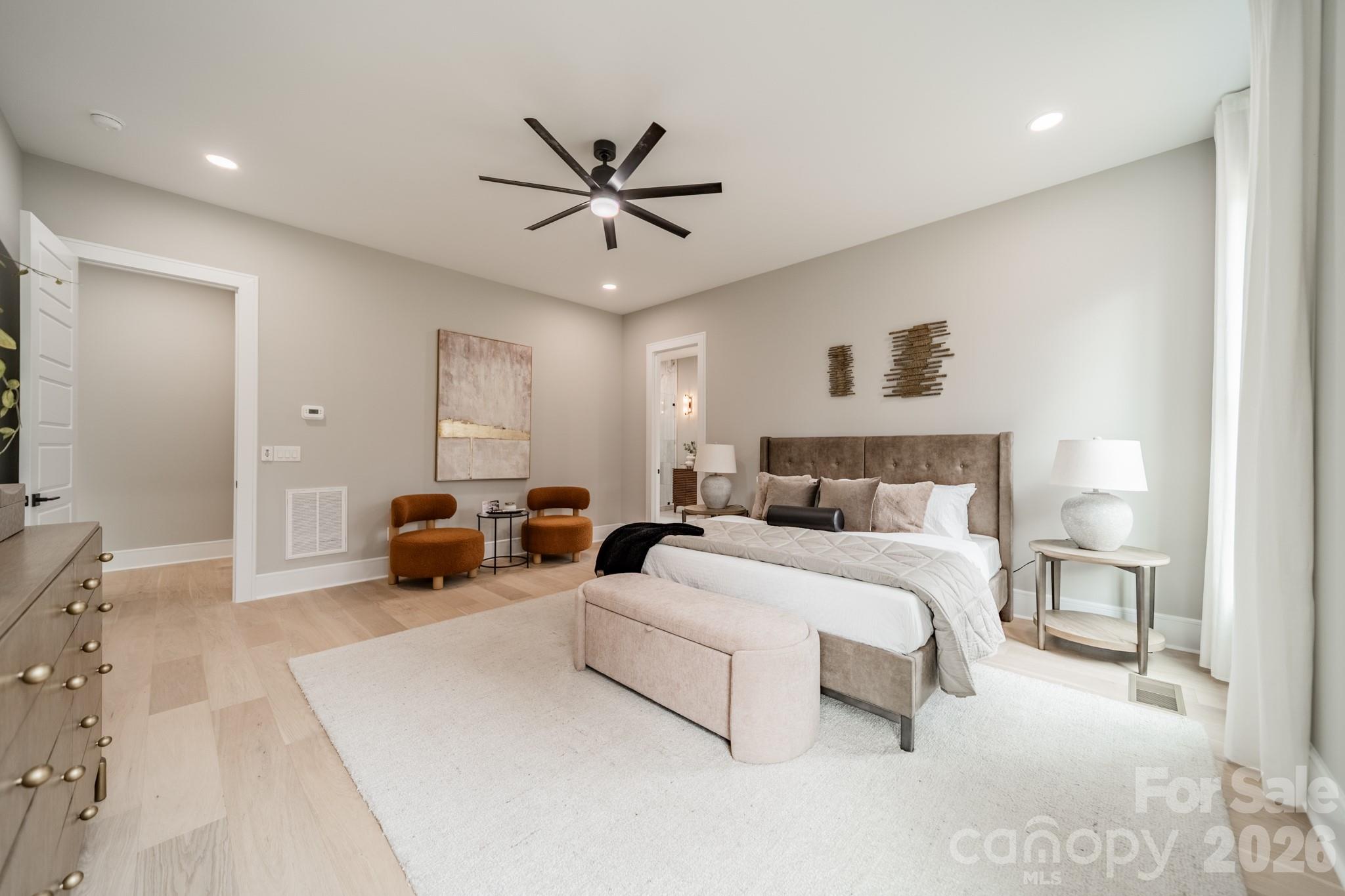 6805 Weddington Matthews Road Weddington, NC 28104 - Photo 19 of 38 a spacious bedroom with a bed a couch and a chandelier