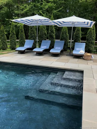 a view of backyard with table and chairs under an umbrella