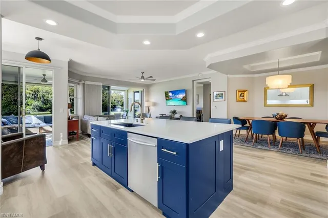 a kitchen with kitchen island granite countertop a sink cabinets and refrigerator