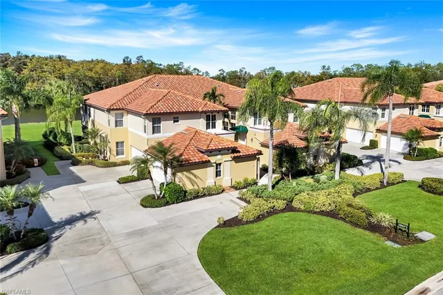 an aerial view of ocean and residential houses with outdoor space