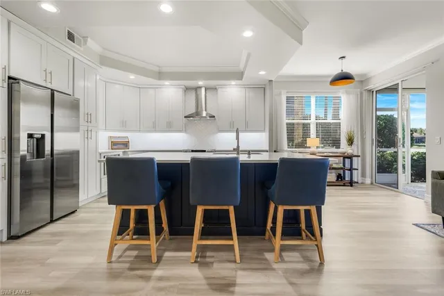 a kitchen with a dining table chairs cabinets and stainless steel appliances