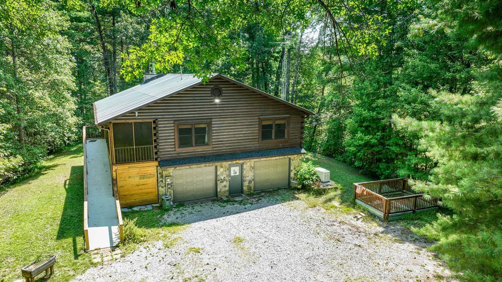 a backyard of a house with plants and large tree
