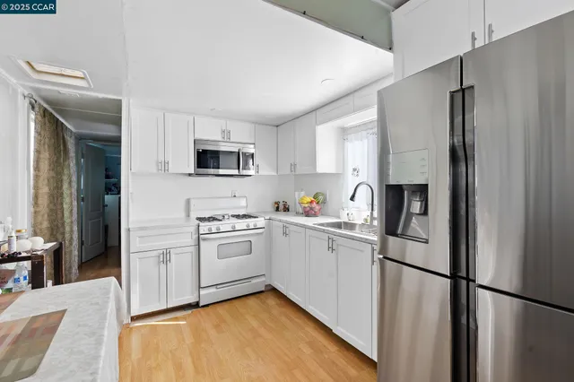 a kitchen with a refrigerator a stove top oven a sink and dishwasher