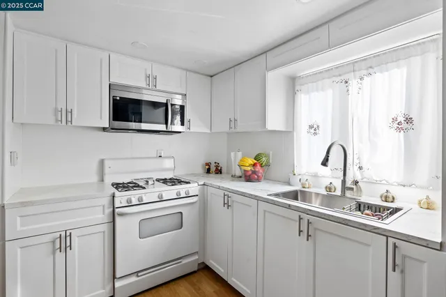 a kitchen with stainless steel appliances granite countertop a sink and a stove top oven