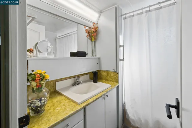 a bathroom with a sink vanity and mirror