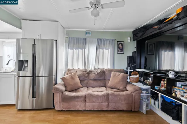 a living room with furniture and a refrigerator