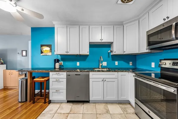 a kitchen with stainless steel appliances granite countertop a stove top oven a sink dishwasher and a refrigerator