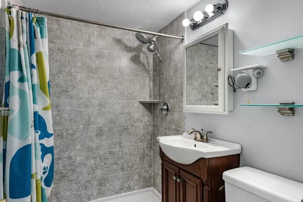 a bathroom with a sink mirror vanity and toilet