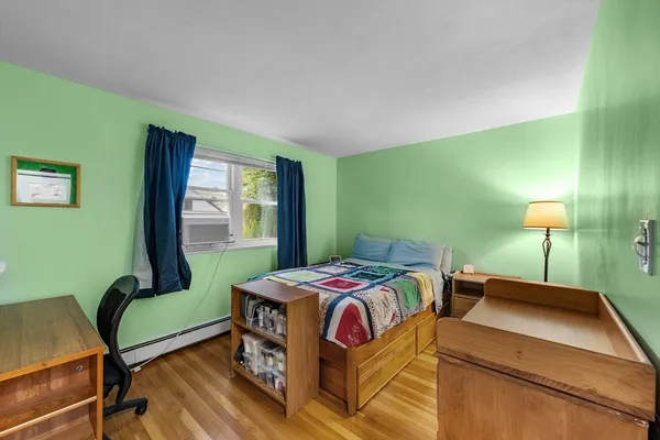 a bedroom with a bed a lamp and a large window