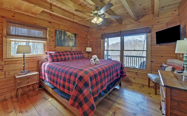 a spacious bedroom with a bed and a flat screen tv