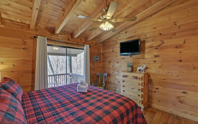 a bedroom with a large bed chandelier and a window