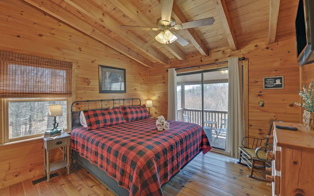 184 Smith Hill Road Blue Ridge, GA 30513 - Photo 35 of 36 a bedroom with a large bed chandelier and a window