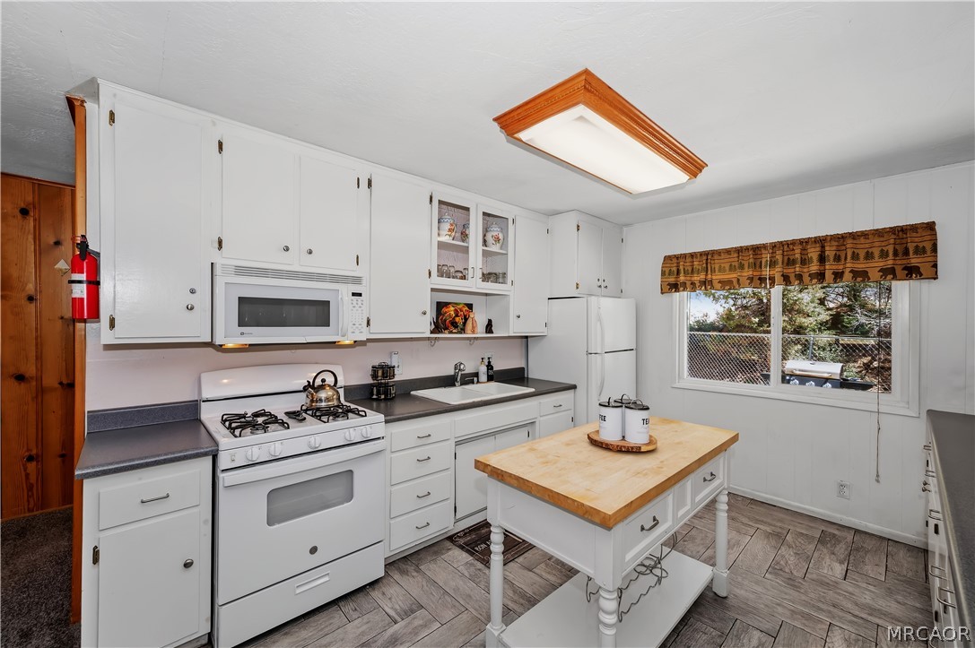 1099 Canyon Road Fawnskin, CA 92333 - Photo 12 of 39 a kitchen with a stove a sink cabinets and a window
