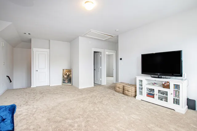a view of a livingroom with entryway and flat screen tv
