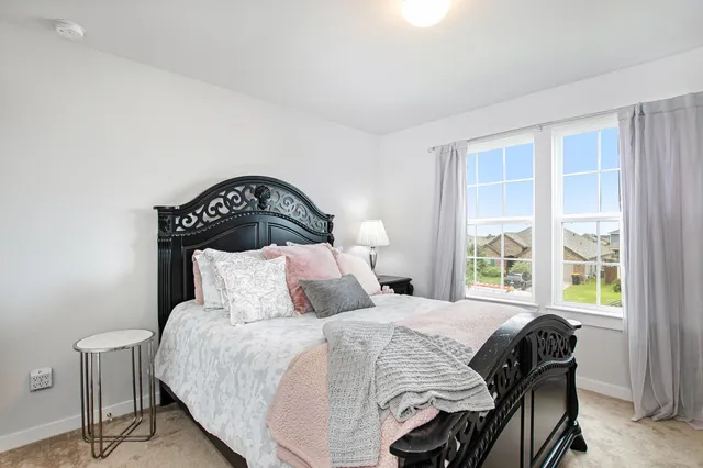 a bedroom with a bed and a large window