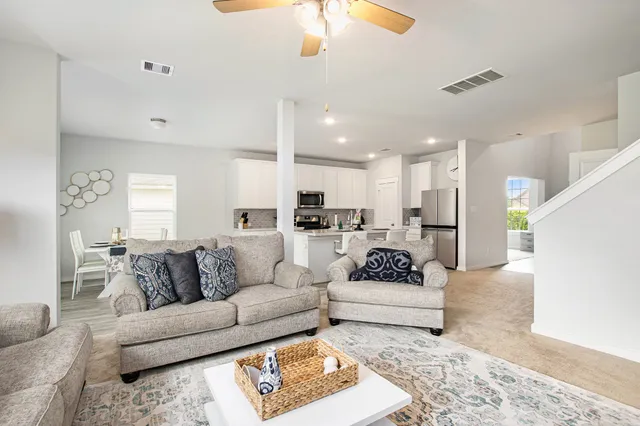 a living room with furniture and kitchen view