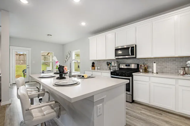 a kitchen with sink a microwave and cabinets