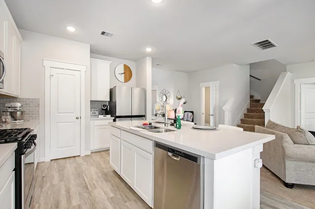 a kitchen with a sink appliances and cabinets