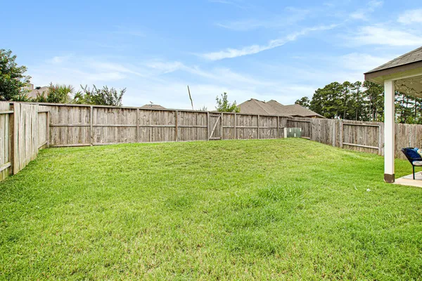 a view of a yard with wooden fence