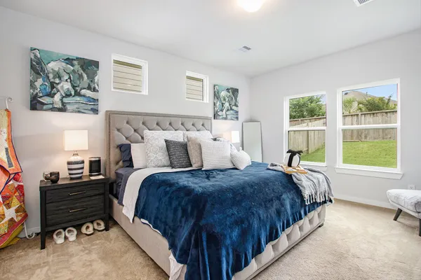 a bed sitting in a bedroom next to a window with a dresser and a window