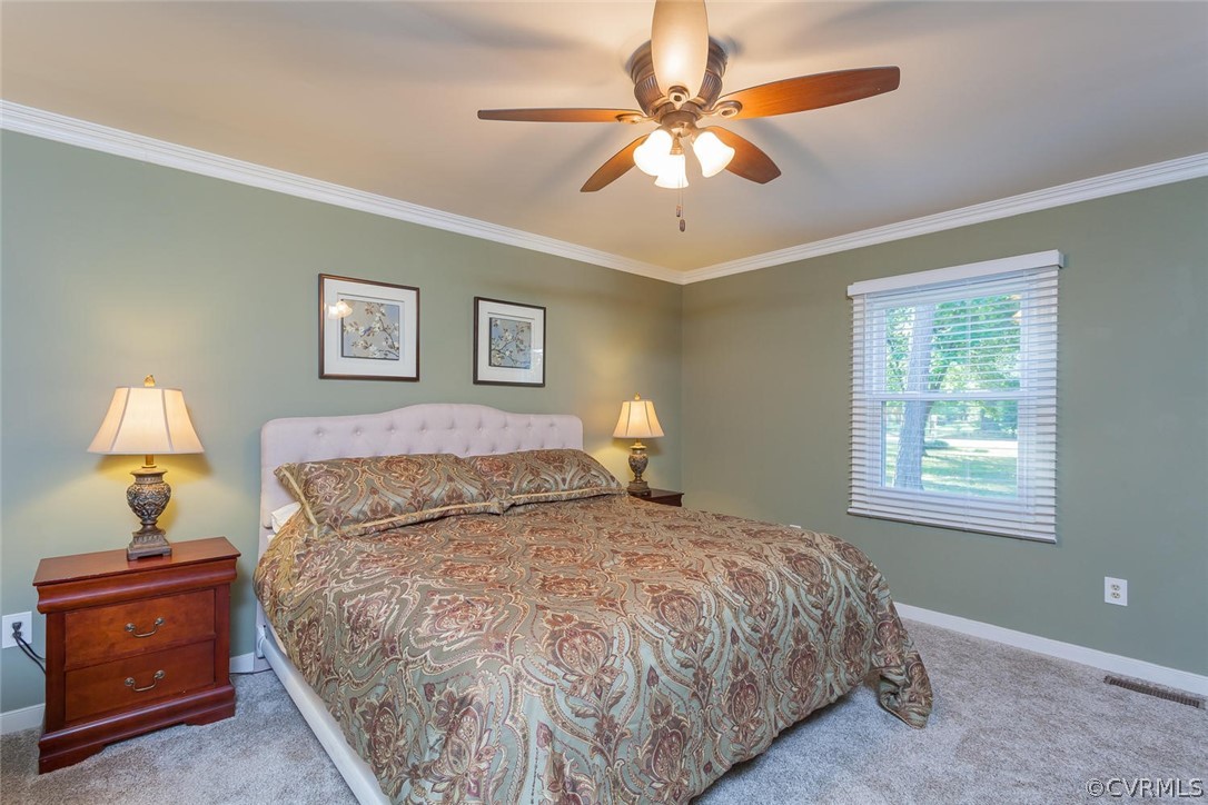 5710 Deep Forest Road Richmond, VA 23237 - Photo 27 of 40 a bedroom with a bed and a chandelier