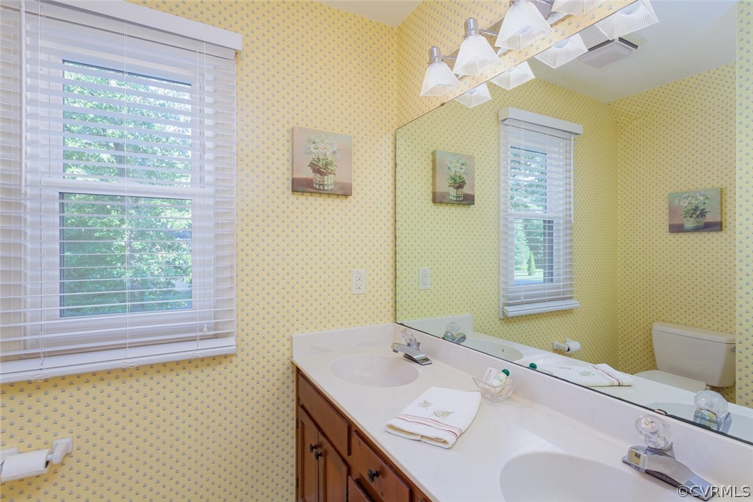 5710 Deep Forest Road Richmond, VA 23237 - Photo 34 of 40 a bathroom with a granite countertop sink a large mirror and a window