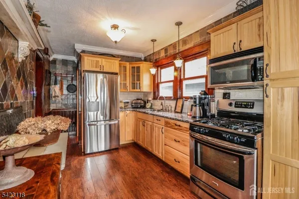 a kitchen with stainless steel appliances a stove a refrigerator and a stove top oven